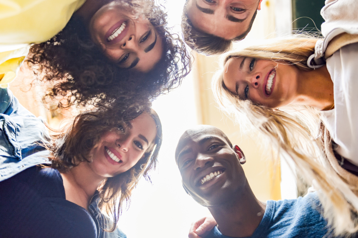 group of people in a circle looking down at the camera